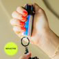 A reflective pepper spray in color opal berry, attached to a keychain.